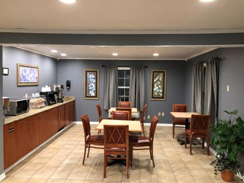 a restaurant with tables and chairs and a counter at First Heritage Inn Rantoul in Rantoul