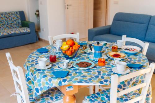 a blue and white table with food and fruit on it at Iolanda Vacanze in Lucugnano