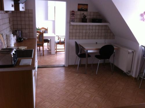 a kitchen and dining room with a table and chairs at Forsthof in Bergen