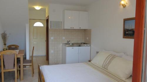a bedroom with a bed and a table and a kitchen at Villa Agava in Vrboska