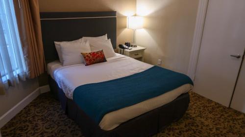 a hotel room with a bed with a pillow on it at City Center Inn and Suites in San Francisco