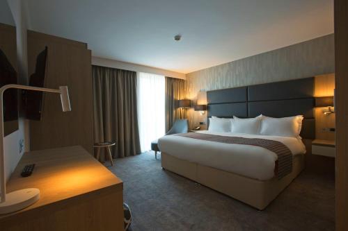 a hotel room with a large bed and a desk at Holiday Inn Manchester - City Centre by IHG in Manchester