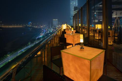 a restaurant with tables and chairs on a balcony at night at Holiday Inn Nanchang Riverside by IHG in Nanchang