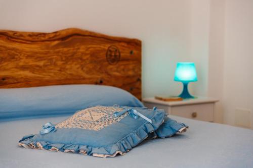 a bed with a wooden headboard and a blue pillow at Iolanda Vacanze in Lucugnano