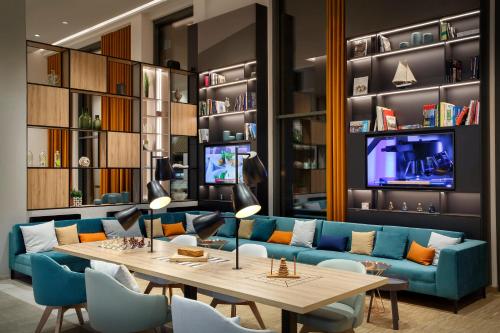 a living room with a blue couch and a table at Holiday Inn - Hamburg - HafenCity by IHG in Hamburg