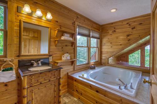 ein Badezimmer mit einer großen Badewanne und einem Waschbecken in der Unterkunft A Smoky Mountain Dream #291 in Sevierville