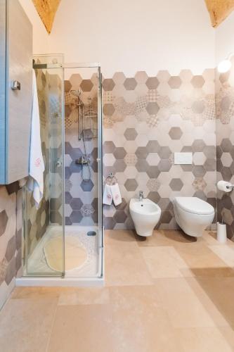 a bathroom with a shower and a toilet and a sink at Iolanda Vacanze in Lucugnano