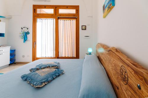 a bedroom with a bed with a wooden head board at Iolanda Vacanze in Lucugnano