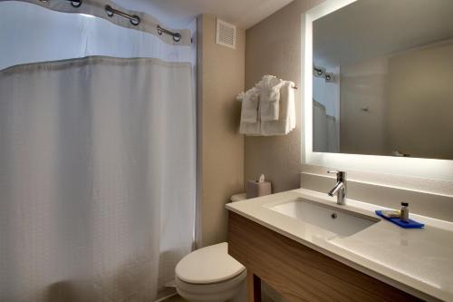 uma casa de banho com um lavatório, um WC e um espelho. em Holiday Inn Express Atlantic City W Pleasantville, an IHG Hotel em West Atlantic City