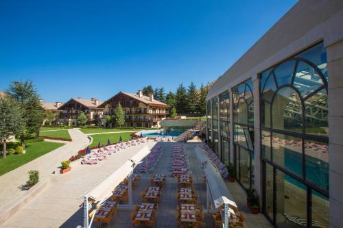 an outdoor patio with tables and chairs outside of a building at InterContinental Mzaar Lebanon Mountain Resort & Spa by IHG in Kfardebian