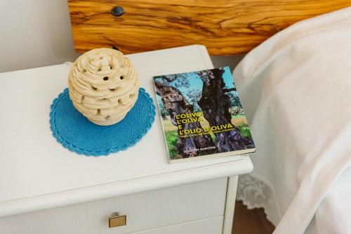 a book on a night stand next to a bed at Iolanda Vacanze in Lucugnano