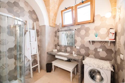 a bathroom with a sink and a washing machine at Iolanda Vacanze in Lucugnano