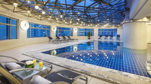 a large indoor pool with chairs and a table at InterContinental Shanghai Pudong, an IHG Hotel in Shanghai