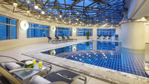 uma grande piscina interior com cadeiras e uma mesa em InterContinental Shanghai Pudong, an IHG Hotel em Xangai