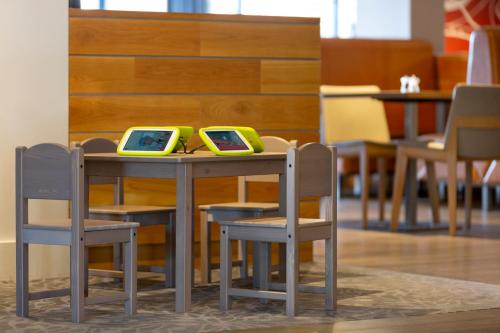 a table and chairs with two monitors on it at Holiday Inn London Brentford Lock by IHG in Brentford