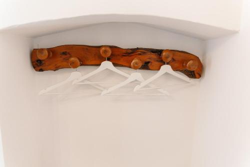 a shelf made from a wooden log with hangers at Iolanda Vacanze in Lucugnano