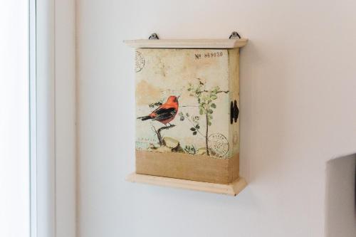 a painting of a red bird on a branch at Iolanda Vacanze in Lucugnano