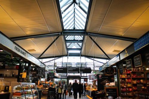 a market with people walking through a store at The heart of Copenhagen-Queen's Neighbor in Copenhagen