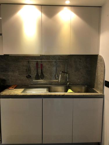 a kitchen with white cabinets and a sink at CASA VACANZA IN COSTA AZZURRA in Menton