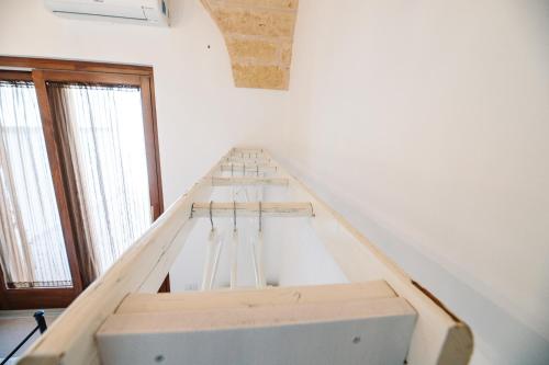 a bed in a room with a white wall at Iolanda Vacanze in Lucugnano