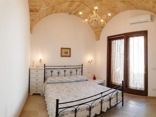 a bedroom with a bed and a chandelier at Iolanda Vacanze in Lucugnano