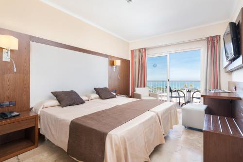 a hotel room with a bed and a large window at Hotel Torre Azul & Spa - Adults Only in El Arenal