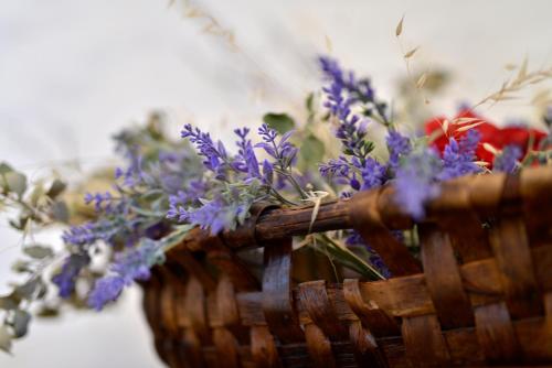 a basket filled with purple flowers on a table at REFÚGIO DO RAPOSO/CASA DENEB (CC) in Montes da Senhora