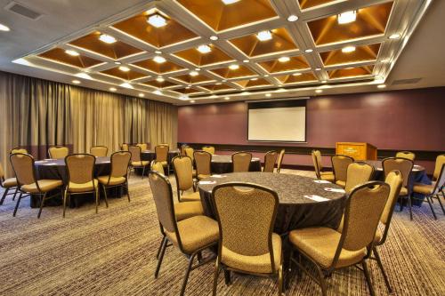 a conference room with a table and chairs and a screen at Crowne Plaza Kitchener-Waterloo by IHG in Kitchener