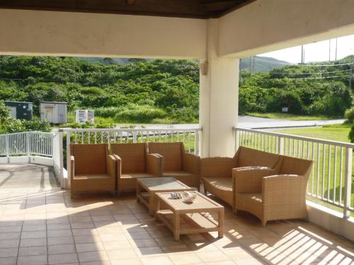 a patio with two couches and a table on a balcony at エコヴィレッジ西表 Eco Village Iriomote in Iriomote