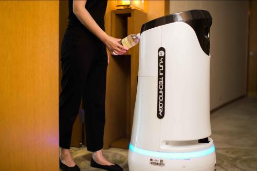a woman is standing next to a white hair dryer at InterContinental Suzhou Hotel by IHG in Suzhou