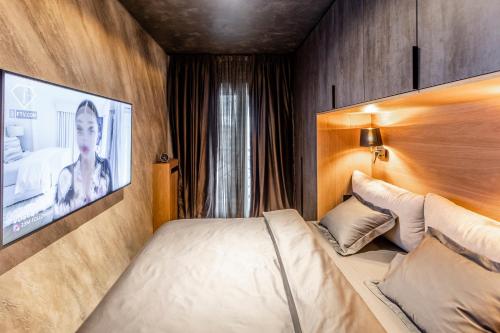 a bedroom with a bed and a tv on the wall at Bella Roe Premium Apartments in Belgrade