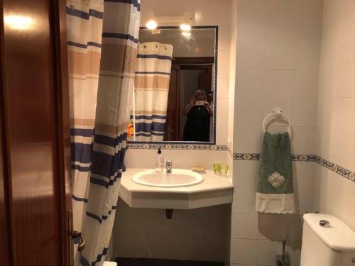 ein Bad mit einem Waschbecken und einem Spiegel in der Unterkunft Apartamento en La Almadraba in Chiclana de la Frontera
