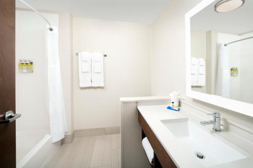 a white bathroom with a sink and a mirror at Holiday Inn Express & Suites - North Brunswick by IHG in North Brunswick