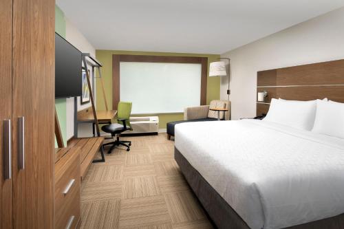 a hotel room with a large bed and a desk at Holiday Inn Express & Suites - North Brunswick by IHG in North Brunswick