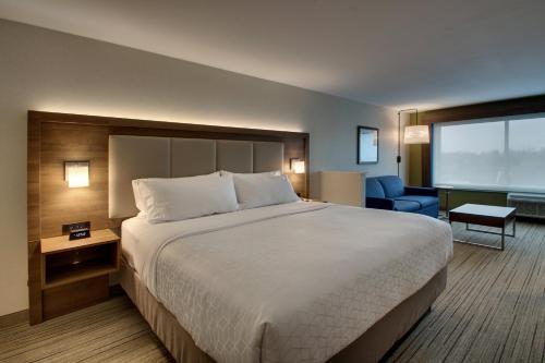 a hotel room with a large bed and a chair at Holiday Inn Express & Suites Mt Sterling North by IHG in Mount Sterling