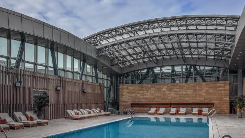 uma piscina num edifício com tecto de vidro em InterContinental Tianjin Yujiapu Hotel & Residences, an IHG Hotel em Binhai