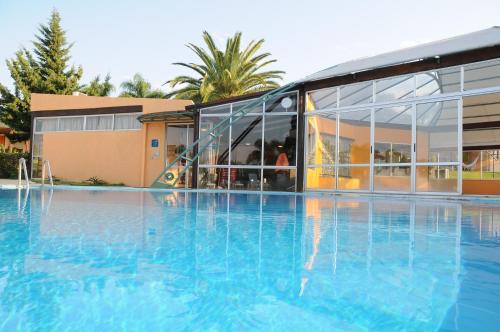 a large swimming pool in front of a building at Arapey Oasis Termal Hotel in Termas del Arapey