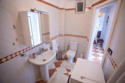 La salle de bains est pourvue d'un lavabo blanc et de toilettes. dans l'établissement Vue sur Mer Avec 2 Terrasses - 100m² - Sur la Côte, à Tanger