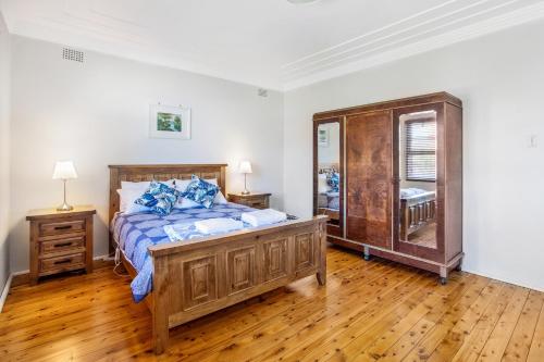 Schlafzimmer mit einem Holzbett und einem Spiegel in der Unterkunft The Summit House in Katoomba