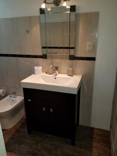 a bathroom with a sink and a mirror and a tub at Hospedaje lo de la Ñata in Trinidad