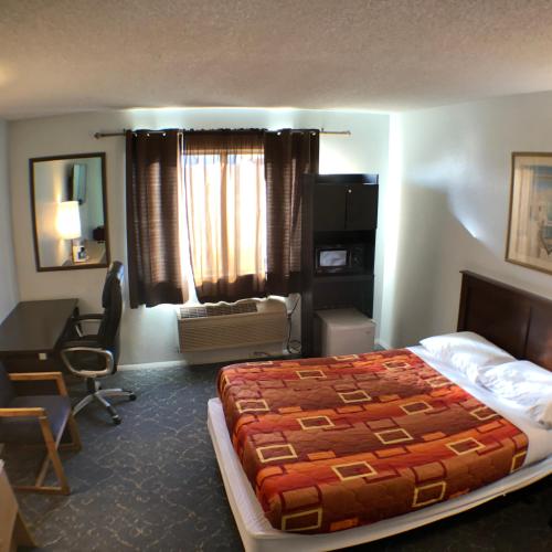 a hotel room with a bed and a desk and a bedroom at Tower 64 Motel & RV in Trinidad