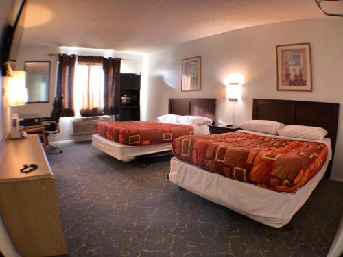 a hotel room with two beds and a desk at Tower 64 Motel & RV in Trinidad