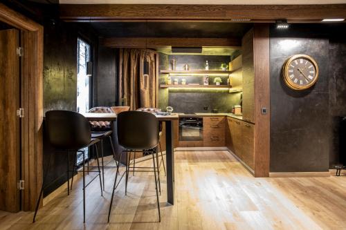 a kitchen with a table and chairs and a clock at Bella Roe Premium Apartments in Belgrade
