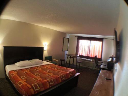 a hotel room with a bed and a desk and a window at Tower 64 Motel & RV in Trinidad