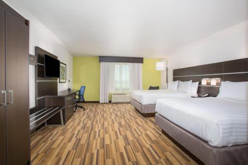 a hotel room with two beds and a flat screen tv at Holiday Inn Express & Suites - Rapid City - Rushmore South by IHG in Rapid City