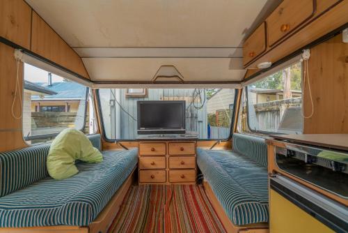 un soggiorno con TV, divano e TV di Rose's Beach Pad - Matarangi Holiday Home a Matarangi