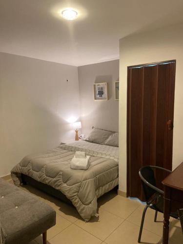 a bedroom with a bed and a table and a chair at Hostal Doña Eliza in Bogotá