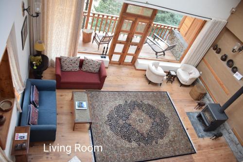 an overhead view of a living room with a couch and a rug at Kudrat - A Boutique Homestay- Tirthan Valley in Banjār