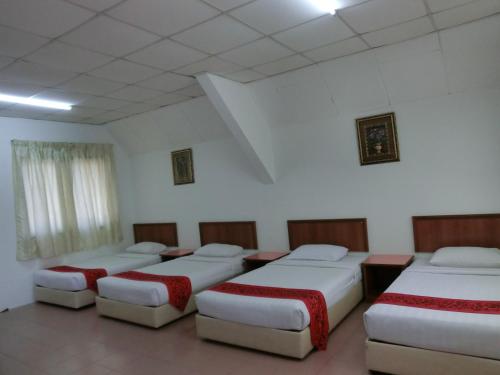 a room with four beds in a room at KT Beach Resort in Kuala Terengganu