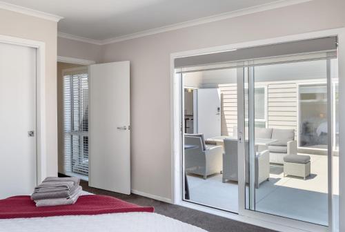 een slaapkamer met witte muren en een kamer met een spiegel bij Easy Days Martinborough in Martinborough 